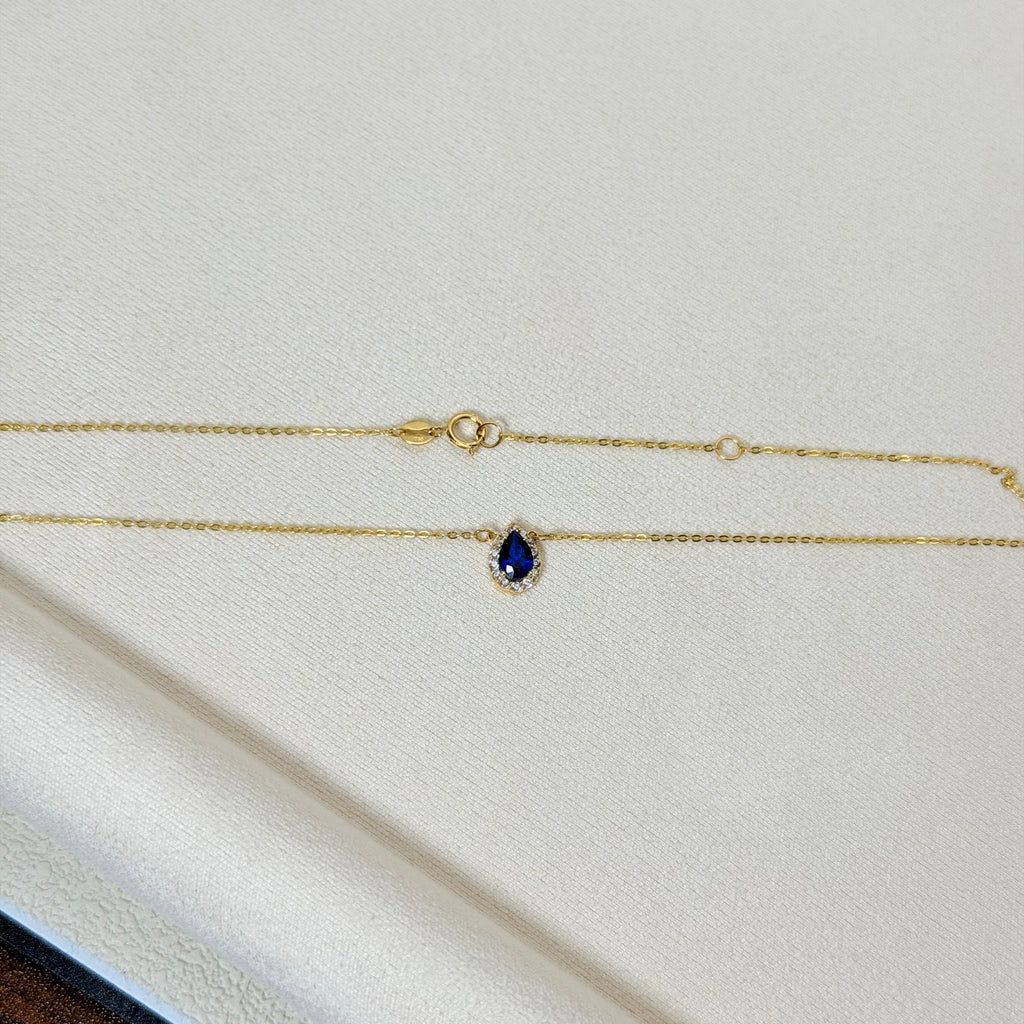 Pear-Shaped Blue Zircon Halo Charm Necklace in Yellow Gold