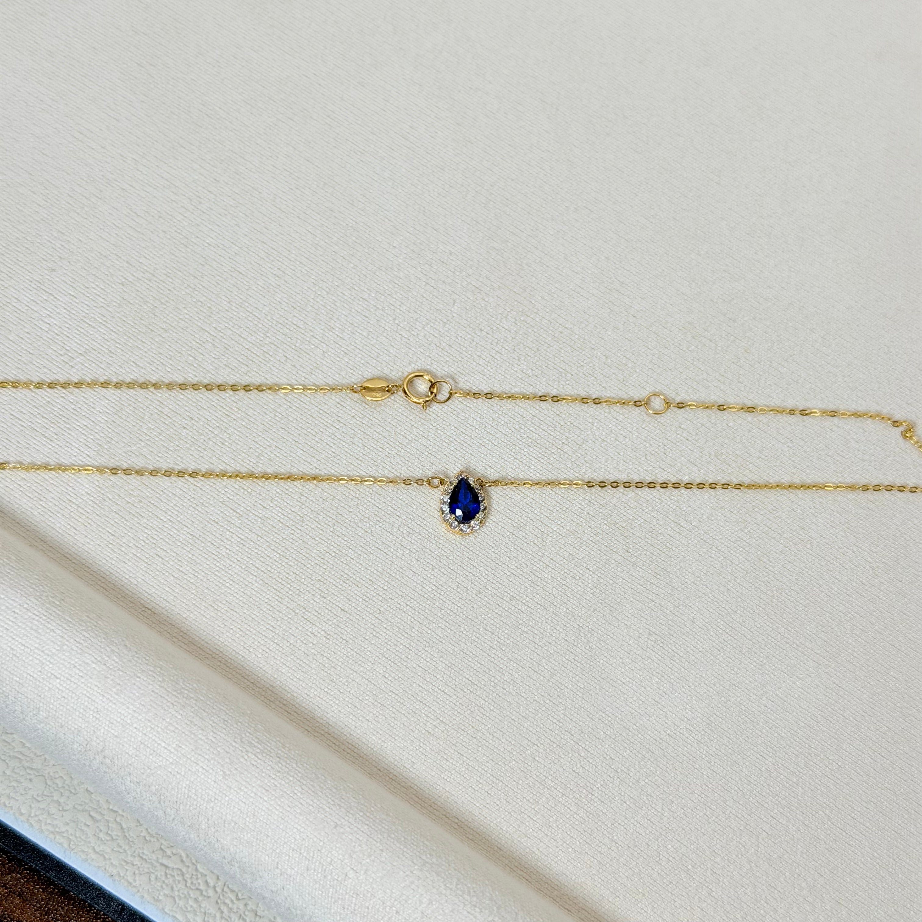 Pear-Shaped Blue Zircon Halo Charm Necklace in Yellow Gold